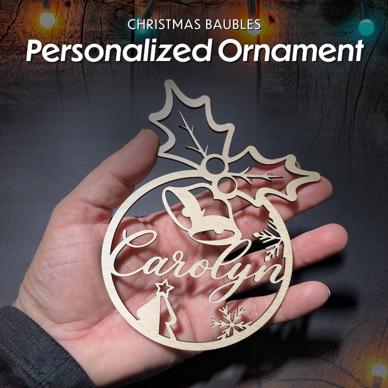 May include: A wooden Christmas bauble with a holly leaf design, a bell, a snowflake, a Christmas tree, and the name "Carolyn" cut out.