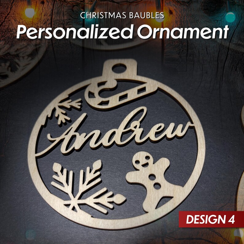 May include: A wooden Christmas bauble with a snowflake, candy cane, gingerbread man, and the name "Andrew" cut out. The bauble is round and has a brown background. The text "DESIGN 4" is visible in the bottom right corner.