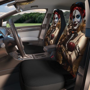 May include: Two car seat covers featuring a steampunk-style illustration of a woman with red hair, blue eyes, and a red and black outfit. The woman is holding a gun in one hand and a wrench in the other. The background is a dark, industrial setting.