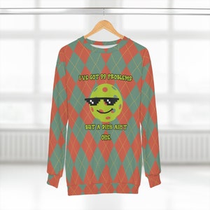 May include: A red and green argyle patterned sweatshirt with a green and yellow disc with a smiley face wearing sunglasses and the text "I've got 99 problems but a dink ain't one."