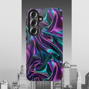 Op de afbeelding: Smartphonehoesje met een abstract, vloeiend ontwerp. De hoes heeft een iriserend patroon in paarse, turquoise en blauwe tinten, wat een dynamisch effect creëert. De hoes heeft een cameramodule met drie lenzen.