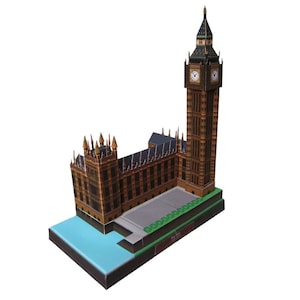 May include: A detailed paper model of the Big Ben clock tower and the Houses of Parliament. The model is predominantly brown with black detailing. The base includes a blue section representing water and a green base.