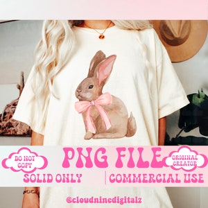 May include: A watercolor illustration of a brown bunny with a pink bow sitting on a white t-shirt. The t-shirt has the text "PNG FILE" in pink letters and the text "SOLID ONLY | COMMERCIAL USE" in black letters. The text "ORIGINAL CREATOR" is in a cloud shape with a pink outline.