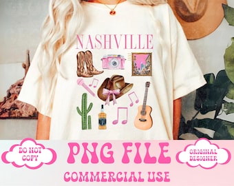 May include: A white t-shirt with a pink and brown design featuring the word "Nashville" and various images including cowboy boots, a camera, a guitar, a cactus, a cowboy hat, and musical notes.