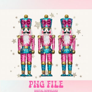 May include: Three pink and blue glitter nutcracker figurines with gold accents and pink bows. The nutcrackers are standing on a white background with silver glitter stars.