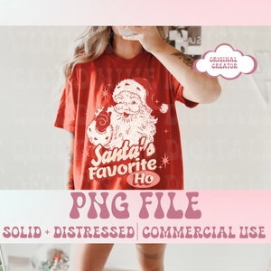 May include: Red t-shirt featuring a white vintage illustration of Santa Claus with the text "Santa's Favourite Ho" in a retro font.