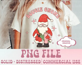 Puede incluir: Una camiseta blanca con un gráfico rosa y rojo de un gnomo sosteniendo una taza verde y rosa. El texto "Bougie Gnome" está escrito en letras rosas sobre el gnomo. El texto "PNG FILE" está escrito en letras rosas debajo del gnomo. El texto "SOLID + DISTRESSED | COMMERCIAL USE" está escrito en letras negras debajo del texto PNG FILE.