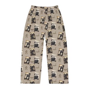 May include: Tan pajama pants with a repeating pattern of vintage photographs, Bigfoot silhouettes, moths, and swans. The photographs appear to be of a group of people. The pants have a relaxed fit and are made of a soft material.
