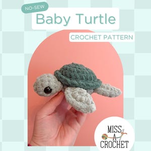 May include: A handmade crocheted baby turtle in grey and green. The image includes the text "Baby Turtle Crochet Pattern" and "Digital Download PDF". The turtle is held in a hand. The background is a light blue checkered pattern.