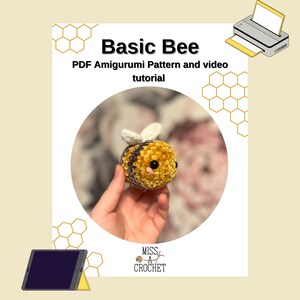 Pode incluir: Um brinquedo de abelha amigurumi de croch&ecirc; com pelo amarelo e marrom, olhos pretos e asas brancas. A abelha est&aacute; sendo segurada em uma m&atilde;o. A imagem inclui o texto "Basic Bee" e "PDF Amigurumi Pattern and video tutorial".