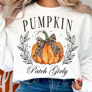 May include: White sweatshirt with a black graphic of a pumpkin with a leopard print bow and the text "Pumpkin Patch Girly".