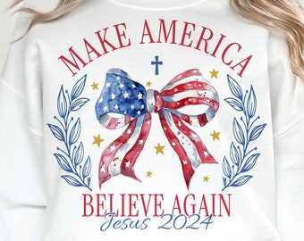 May include: White sweatshirt with a red, white, and blue bow with a cross and stars. The text "Make America Believe Again Jesus 2024" is printed on the sweatshirt.