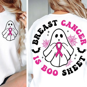 May include: White sweatshirt featuring a ghost wearing a pink ribbon, with the text "Breast Cancer is Boo Sheet" on the back. The design includes bats, spiderwebs, and stars. A smaller ghost with a pink ribbon is on the front.