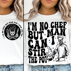 May include: White sweatshirt with a black graphic print that says "I'm no chef but man can I stir the pot". The graphic includes a skull wearing a chef's hat and holding a spatula and whisk.
