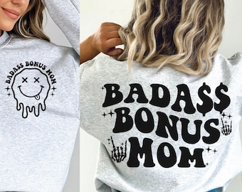 May include: Gray sweatshirt with the text "BADASS BONUS MOM" in black with a dripping smiley face on the front and a dollar sign and skeleton hands on the back.