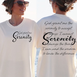 May include: White t-shirt with black text that reads "God, grant me the serenity to accept the things I cannot change, the serenity to change the things I can, and the wisdom to know the difference."
