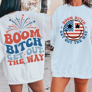 Pu&ograve; includere: Due felpe bianche con un design di bandiera americana rosso, bianco e blu. Una felpa ha un viso sorridente con il testo "BOOM BITCH GET OUT THE WAY". L'altra felpa ha un design di fuochi d'artificio con il testo "BOOM BITCH GET OUT THE WAY".