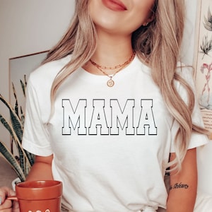 May include: White t-shirt with the word "MAMA" printed in black block letters.