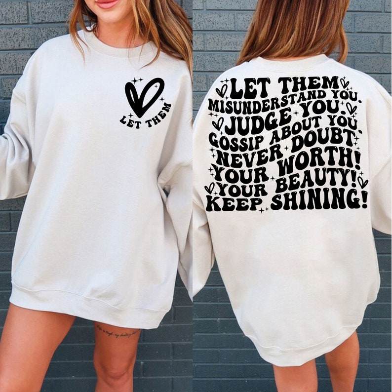 May include: A white sweatshirt with a black heart and the text "Let them" on the left side and the text "Let them misunderstand you. Judge you. Gossip about you. Never doubt your worth! Your beauty! Keep shining!" on the back.