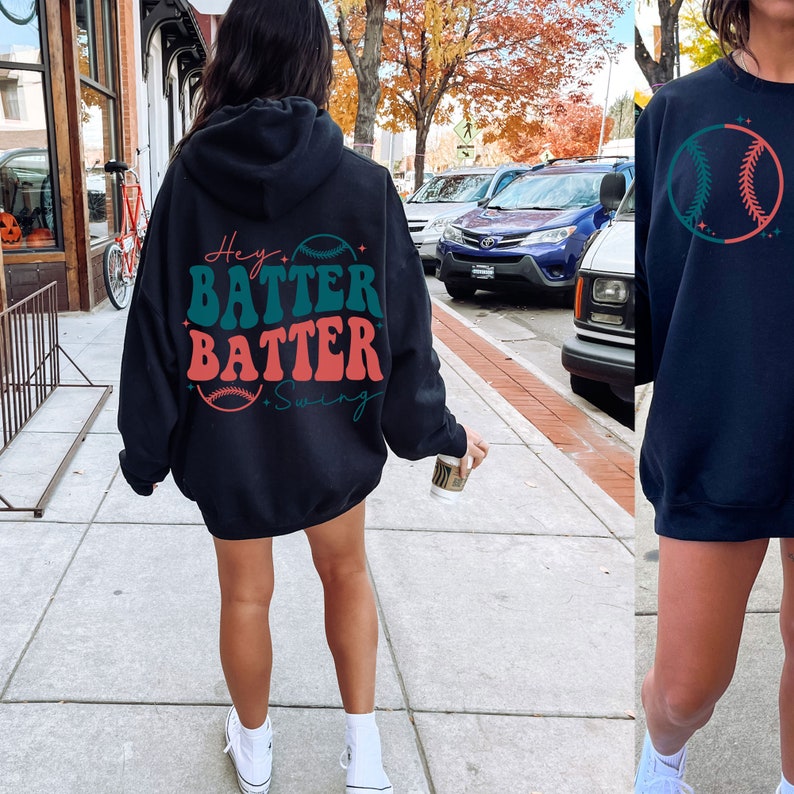 May include: Black hooded sweatshirt with the text "Hey Batter Batter Swing" and a baseball graphic in green, red, and white.