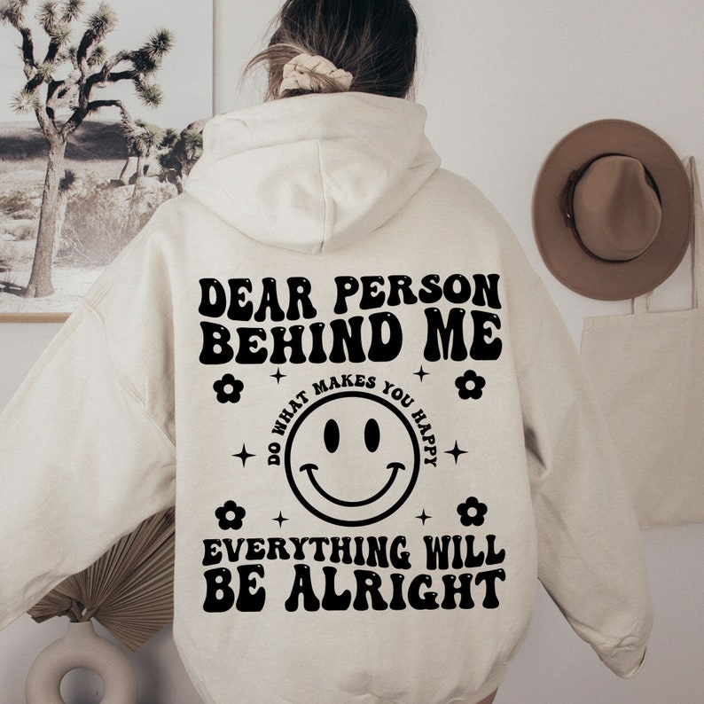 K&ouml;nnte beinhalten: Ein wei&szlig;er Hoodie mit einem schwarzen Aufdruck, der "Liebe Person hinter mir tu, was dich gl&uuml;cklich macht alles wird gut" mit einem Smiley in der Mitte sagt.