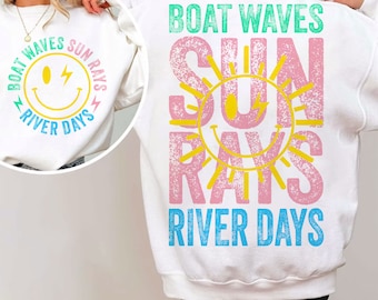 Op de afbeelding: Wit sweatshirt met een roze en gele zon graphic en de tekst "BOAT WAVES SUN RAYS RIVER DAYS".