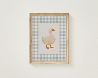 May include: Framed artwork featuring a white goose with orange feet and beak. The goose is centered on a light background, framed by a blue and white gingham pattern. The wooden frame adds a rustic touch to the artwork.