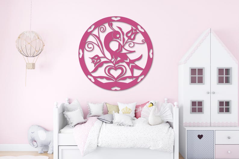 Pode incluir: Decora&ccedil;&atilde;o de parede de madeira rosa com um design circular que apresenta um p&aacute;ssaro, flores e cora&ccedil;&otilde;es. A decora&ccedil;&atilde;o est&aacute; montada em uma parede rosa em um quarto com uma cama branca e uma casa de bonecas branca.
