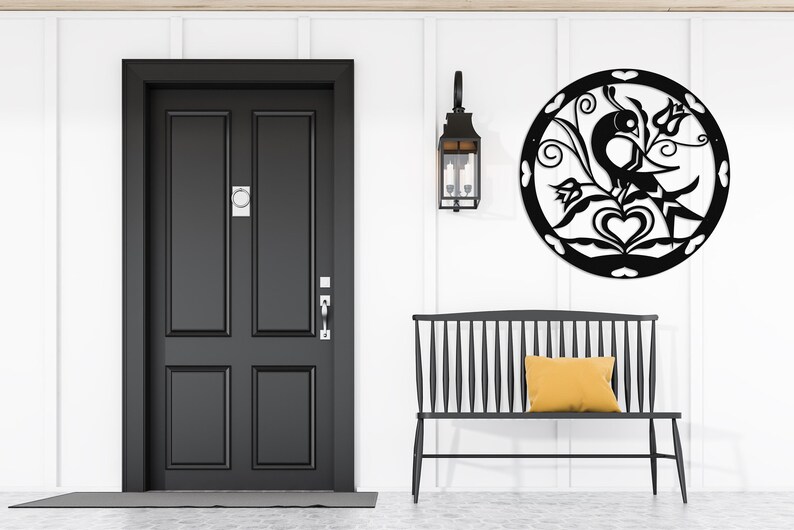 Pode incluir: Decora&ccedil;&atilde;o de parede de metal preto com um p&aacute;ssaro estilizado com flores e cora&ccedil;&otilde;es. A decora&ccedil;&atilde;o est&aacute; pendurada em uma parede branca acima de um banco preto.