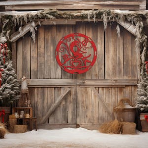 Pode incluir: Uma porta de celeiro de madeira r&uacute;stica com um recorte circular decorativo vermelho com um design de p&aacute;ssaro. A porta &eacute; ladeada por duas pequenas &aacute;rvores de con&iacute;feras cobertas de neve com detalhes de fita vermelha. A cena se passa em um cen&aacute;rio de neve e um celeiro de madeira.