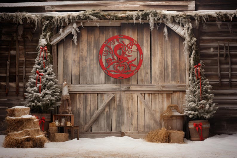 Pode incluir: Uma porta de celeiro de madeira r&uacute;stica com um recorte circular decorativo vermelho com um design de p&aacute;ssaro. A porta &eacute; ladeada por duas pequenas &aacute;rvores de con&iacute;feras cobertas de neve com detalhes de fita vermelha. A cena se passa em um cen&aacute;rio de neve e um celeiro de madeira.