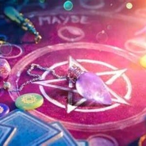 Könnte beinhalten: Eine mystische Szene mit einer lila Anhängerkette, Würfeln und Tarotkarten. Die Szene spielt auf einer rosa Oberfläche mit einem Pentagramm-Design und dem Wort "MAYBE" in Weiß.