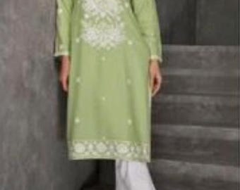May include: A light green tunic with white embroidery and long sleeves, paired with white pants. The tunic features detailed floral patterns around the neckline and hem. The outfit is worn with gold-colored sandals.
