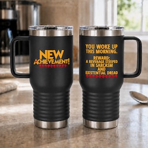 May include: A black stainless steel travel mug with a handle and a clear lid. The front features yellow text reading NEW ACHIEVEMENT! with red skull icons. The back displays yellow text reading YOU WOKE UP THIS MORNING. REWARD: A BEVERAGE STEEPED IN SARCASM AND EXISTENTIAL DREAD with red skull icons.