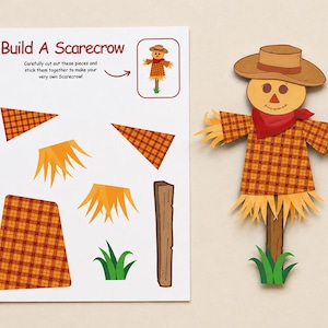 May include: A Build A Scarecrow paper craft activity sheet featuring cut-out pieces including a plaid shirt, straw accents, a wooden post, and green grass, alongside a fully assembled scarecrow figure wearing a brown hat and red scarf.