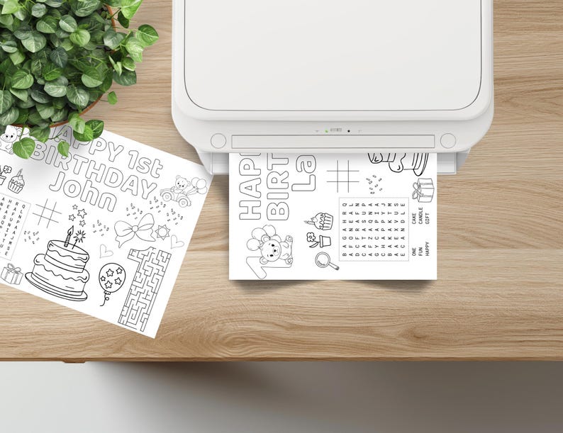 Puede incluir: Una impresora blanca imprime una p&aacute;gina para colorear en blanco y negro. La p&aacute;gina dice "HAPPY 1st BIRTHDAY John" e incluye im&aacute;genes de una tarta, un laberinto y un globo. Tambi&eacute;n se ve una segunda p&aacute;gina.