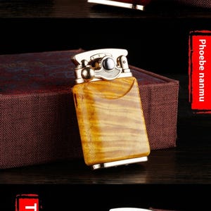 May include: A gold-toned lighter with a wood grain design. The lighter has a silver knob and a silver ring around the top.