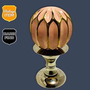 May include: A vintage decorative object featuring a pink, petal-shaped sphere with gold accents, mounted on a gold-colored pedestal. The sphere is a soft pink color, and the gold accents provide a striking contrast. The object is labeled "Vintage Item" and "Rare Find".