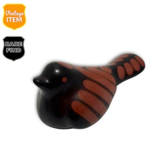 May include: A ceramic bird figurine in black and brown. The bird has a rounded body and a small beak. The wings and tail feature a brown pattern. The image includes a "Vintage Item" and "Rare Find" badge.