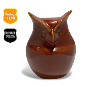 May include: A brown ceramic owl figurine with a glossy finish. The owl has large eyes, a pointed beak, and pointed ears. The figurine is labeled "Vintage Item" and "Rare Find".