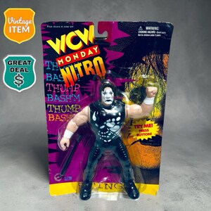 Op de afbeelding: Een WCW Monday Nitro worstelactiefiguur in de originele verpakking. Het figuur heeft witte schmink, een zwart mouwloos shirt met een witte skelet-handafdruk en een zwarte broek. De kaart bevat de tekst WCW MONDAY NITRO en THUMP BASH.
