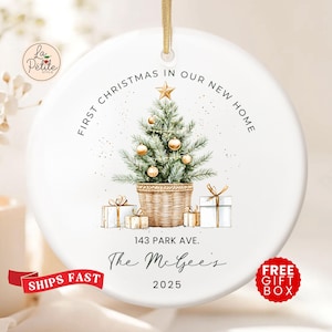 May include: A round white ceramic ornament featuring a watercolor illustration of a Christmas tree in a woven basket with gold ornaments and a star topper. Text reads: FIRST CHRISTMAS IN OUR NEW HOME, 143 PARK AVE., The McGee's, and 2025.