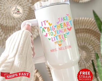 Könnte beinhalten: Weißer isolierter Becher mit Griff, mit dem Text "It takes a big heart to teach little minds" in bunten Buchstaben und Herzen. Der Name "Mrs. Nelson" ist darunter aufgedruckt. Inklusive Strohhalm und Deckel.