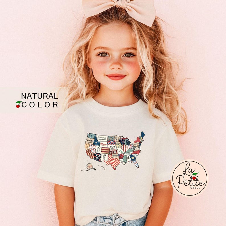May include: A young girl wearing a white t-shirt with a patchwork American flag design. The shirt has the text "La Petite Style" on the bottom right corner.