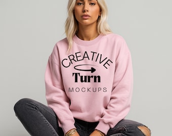 Könnte beinhalten: Hellrosa Sweatshirt mit dem schwarzen Text "CREATIVE Turn MOCKUPS". Das Sweatshirt hat einen Rundhalsausschnitt und wird mit dunkelgrauen Jeans getragen.