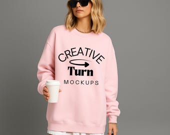 Könnte beinhalten: Ein hellrosa Sweatshirt mit dem Text "CREATIVE Turn MOCKUPS" in Schwarz. Das Sweatshirt wird mit Sonnenbrille und einem weißen Rock getragen. Eine weiße Pappbecher wird in der Hand gehalten.