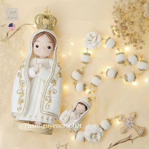 Puede incluir: Una figura religiosa de ganchillo hecha a mano de una mujer que lleva una corona y una túnica blanca con detalles dorados. También hay un rosario de ganchillo con cuentas blancas y una cruz dorada. La imagen incluye el texto "PDF Pattern" y el nombre de usuario de Instagram del vendedor.