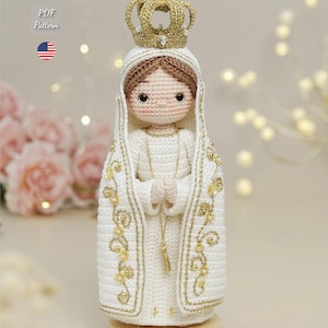May include: A handmade crochet doll depicting a religious figure, dressed in a white robe with gold detailing and a gold crown. The doll has brown hair and clasped hands. The image includes the text "PDF Pattern" and the seller's Instagram handle.