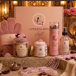 May include: A Goddess Box Aset gift set featuring a pink exfoliating glove, a jar of Intoxicating body scrub, a jar of beauty butter, a tall pink candle with crystals, a Love Spell spray bottle, and a long strand of pink beads.