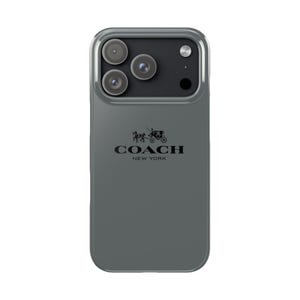 Puede incluir: Una funda gris para teléfono con borde transparente. Presenta tres lentes de cámara y un flash. El logotipo de Coach, un carruaje tirado por caballos, está impreso en negro con las palabras "NEW YORK" debajo.